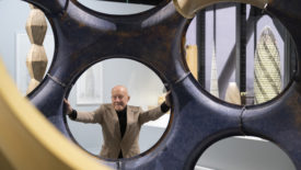 norman foster poses with a fly's eye dome prototype at an exhibition